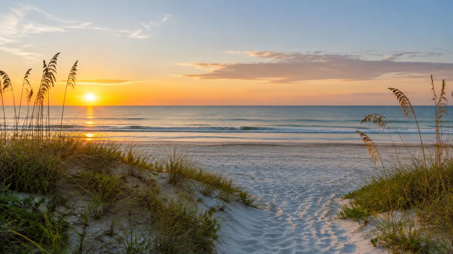 Quiet Florida beach at sunrise with sea oats on the dunes